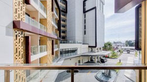 Un bâtiment moderne doté d’une façade en verre, d’une cour intérieure avec une fontaine et d’un espace de stationnement.