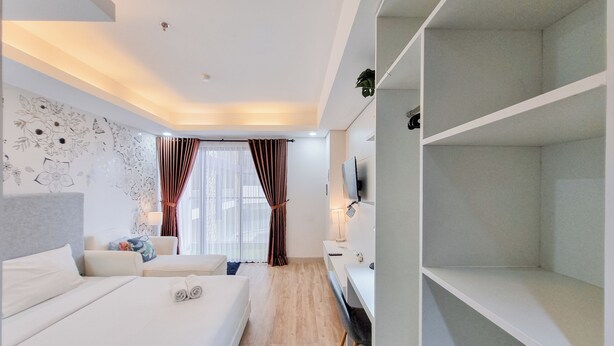 Une chambre d’hôtel moderne équipée d’un grand lit, d’un bureau, d’une télévision et d’une armoire.