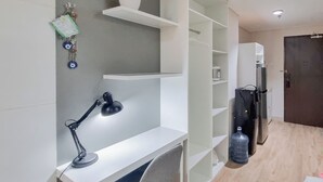 Une pièce moderne et bien éclairée, équipée d’un bureau, d’une chaise et d’étagères.