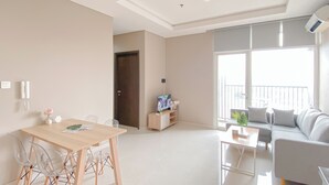 A modern living room with a sofa, a coffee table, and a TV stand. - Good Deal and New Furnished 2BR Ciputra International Apartment (Jakarta)
