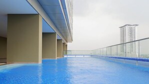 An indoor swimming pool with a view of a high-rise building in the background. - Wonderful Thematic 2BR at Praxis Apartment (Surabaya)