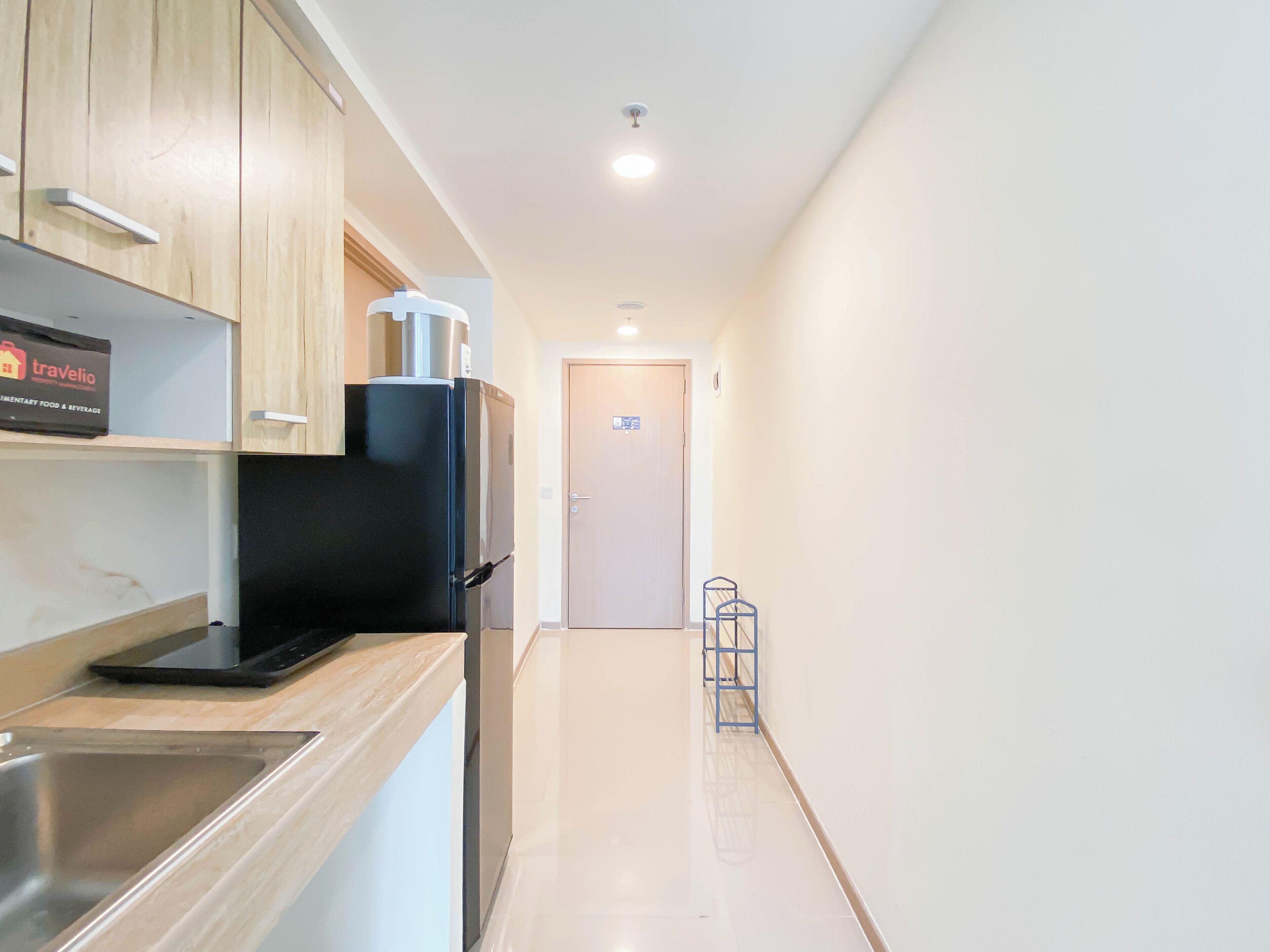 A modern kitchen with a refrigerator, a sink, and a countertop.