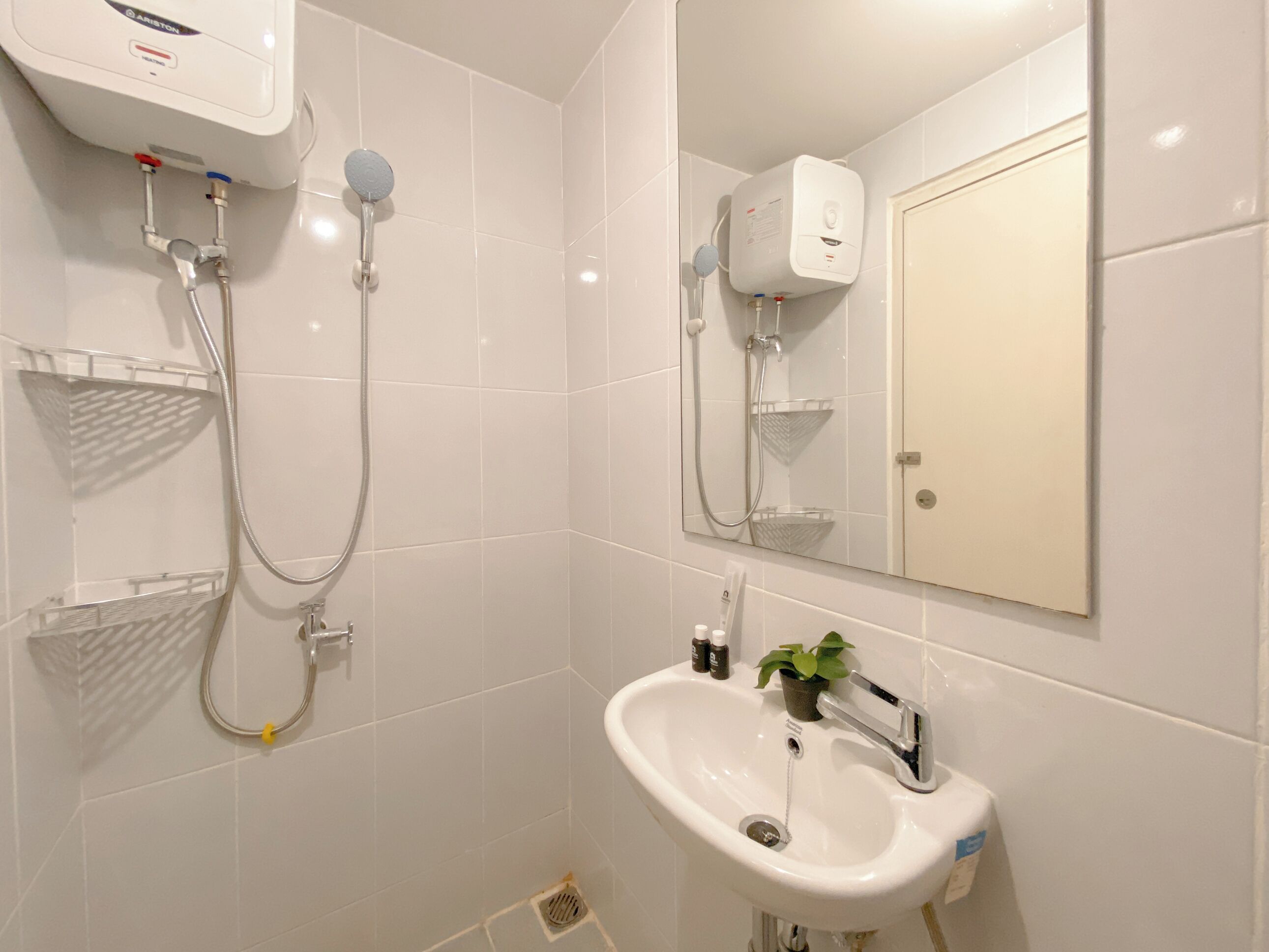A modern bathroom with a shower, a sink, a mirror, and a toilet.