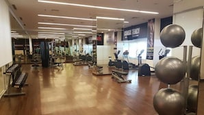 A gym with various exercise equipment, including treadmills and weight machines. - Pleasant and Restful Studio at Orchard Supermall Mansion Apartment (Surabaya)