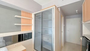 A bedroom with a bunk bed, a wardrobe with glass doors, and a small desk. - Pleasant and Restful Studio at Orchard Supermall Mansion Apartment (Surabaya)