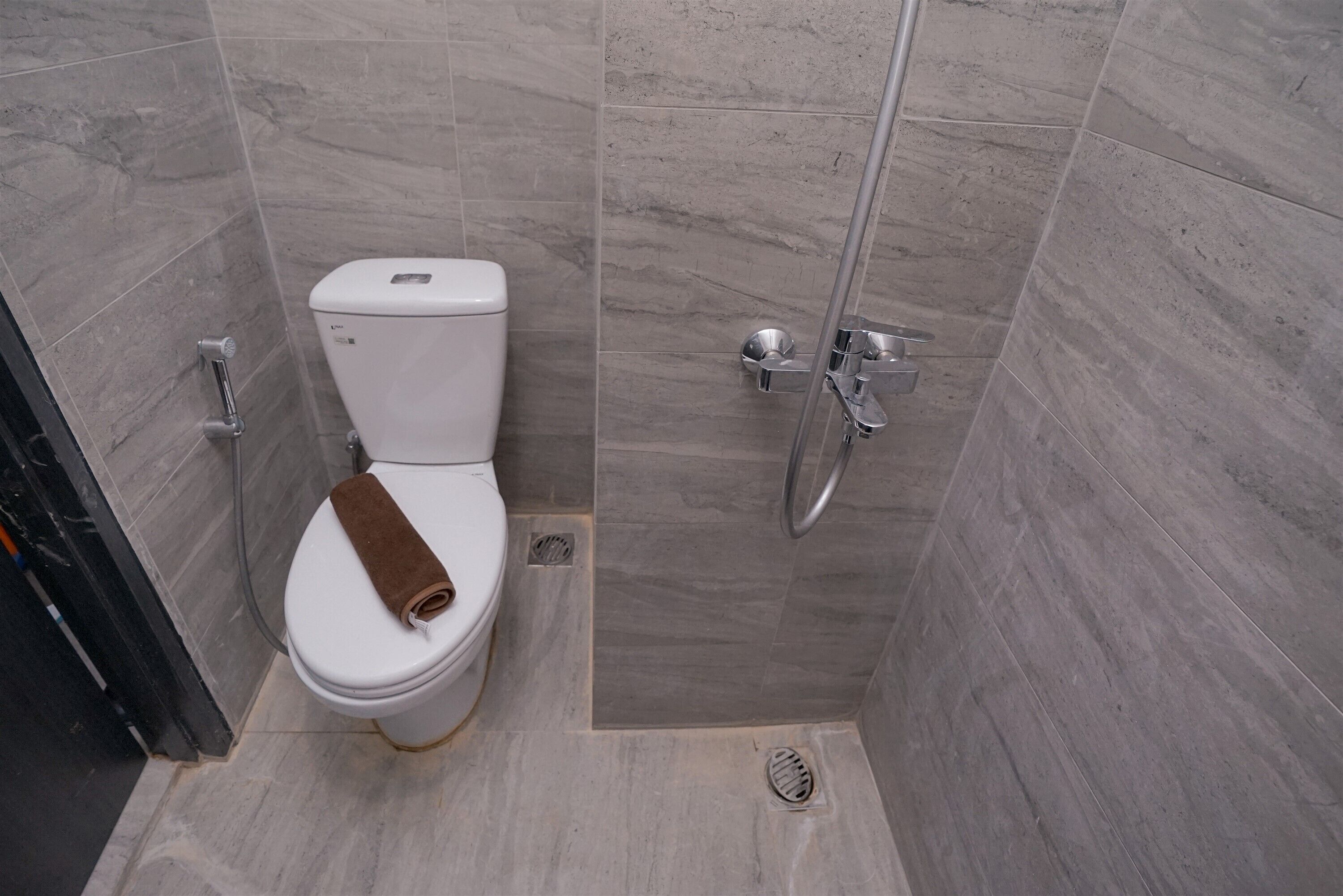 A modern bathroom with a toilet, a shower, and a sink.