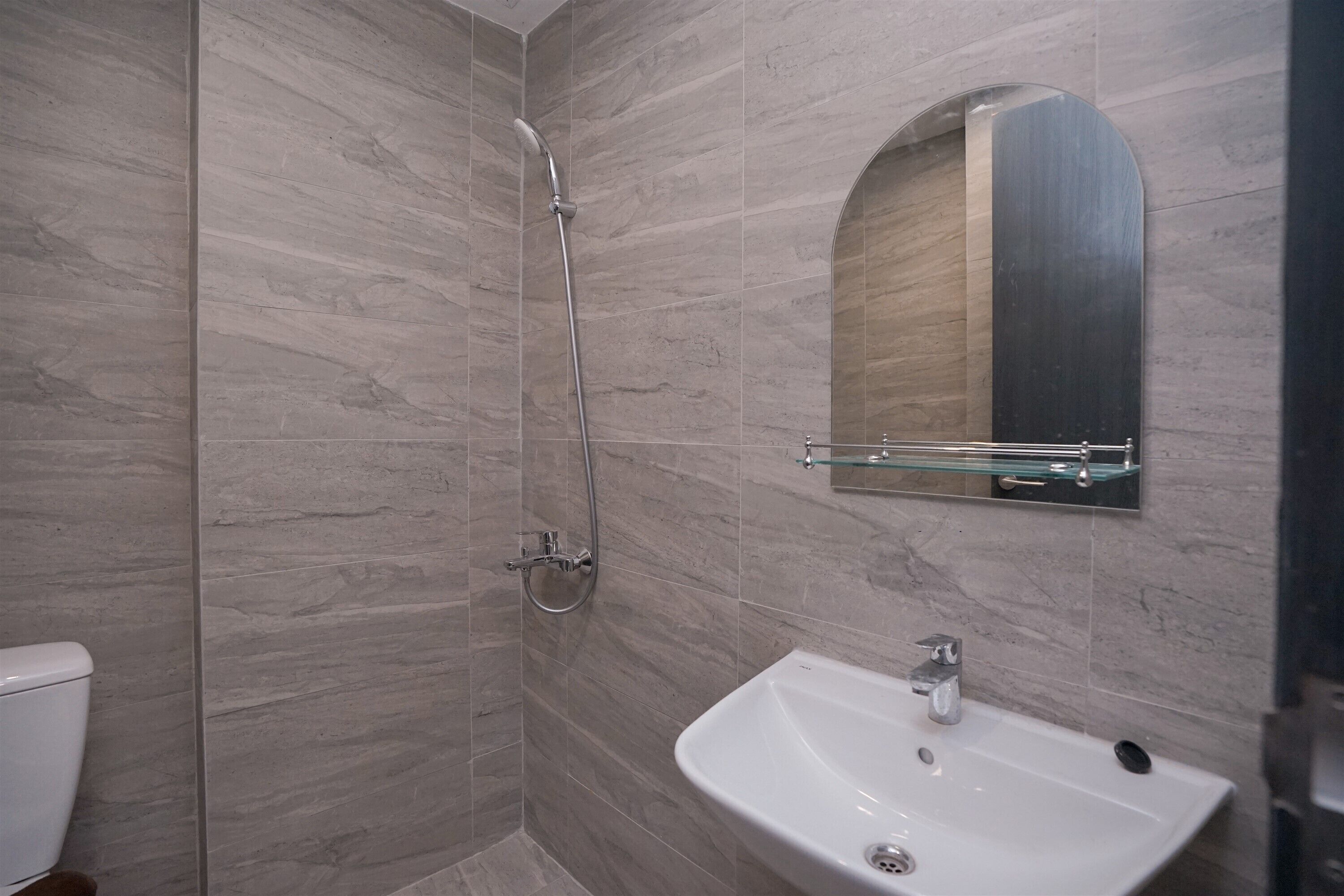 Ein Badezimmer mit Dusche, Waschbecken und Spiegel.