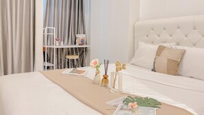Une chambre à coucher bien rangée, avec un lit, une table de chevet et une petite étagère où sont posés des livres et des objets décoratifs.