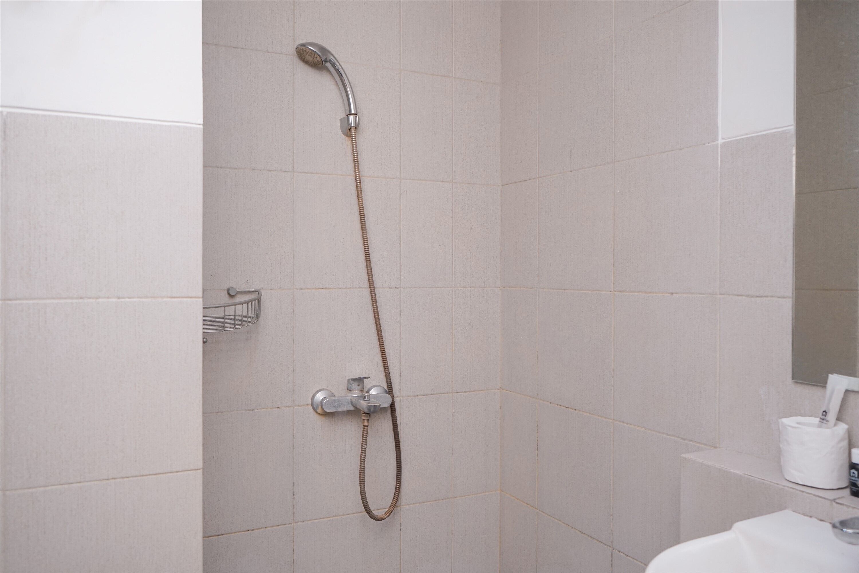 A bathroom with a shower, a sink, and a toilet.