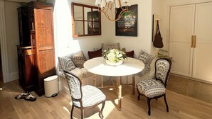 A dining area with a round table, four patterned chairs, a chandelier, and a skylight. - 6bedroom, 4bath, chefs kitchen, central air, ping pong, walking distance to town (Tisbury)