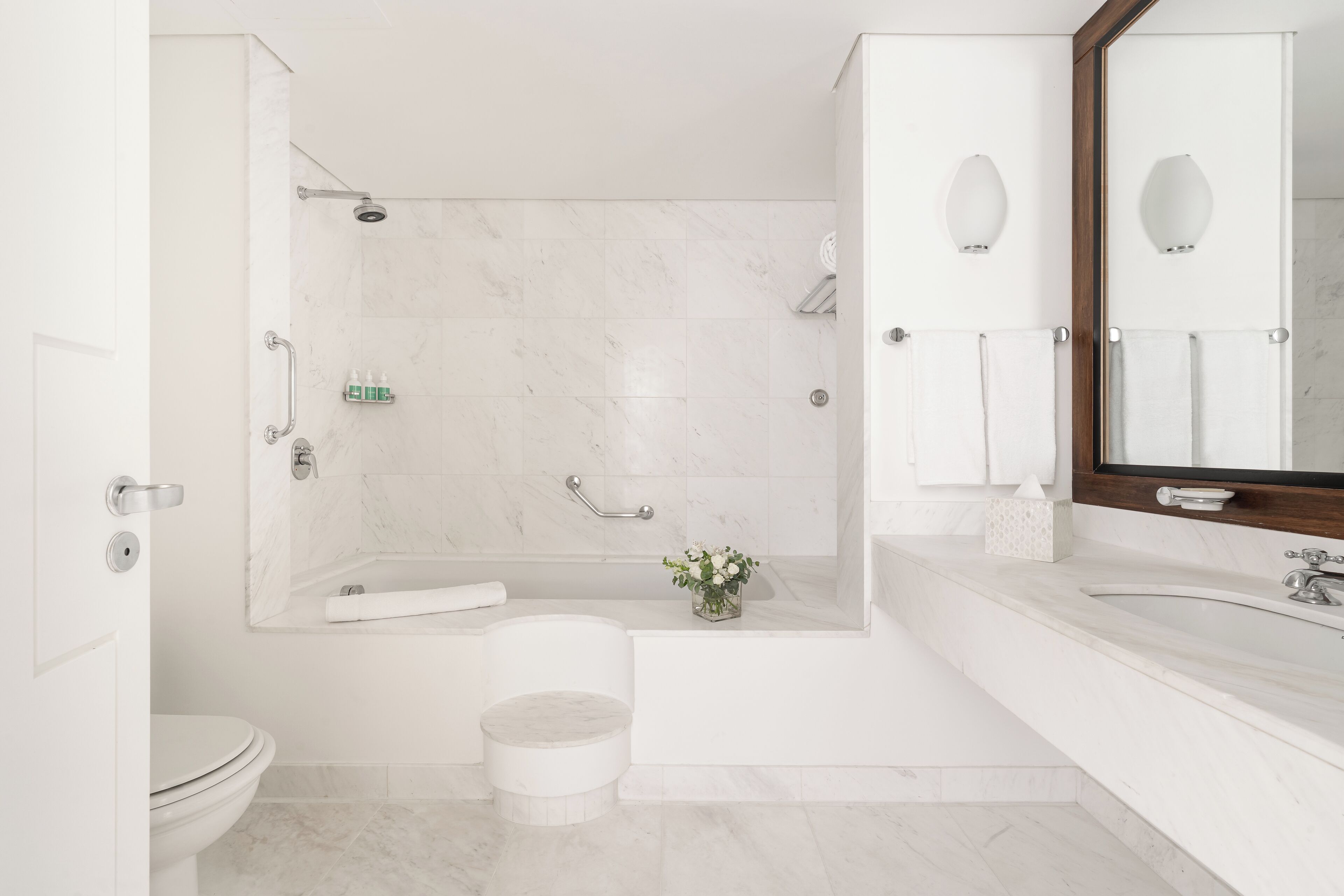 Une salle de bain moderne équipée de toilettes, d’une baignoire, d’une douche et d’un lavabo.