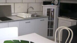 A compact kitchen with a sink, a microwave, and a cabinet. - Apartment Jadranka (Lumbarda)