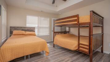 A bedroom with two beds, wooden headboards, and a ceiling fan.