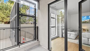 A modern apartment with a balcony, large windows, and a view of the Hollywood sign.