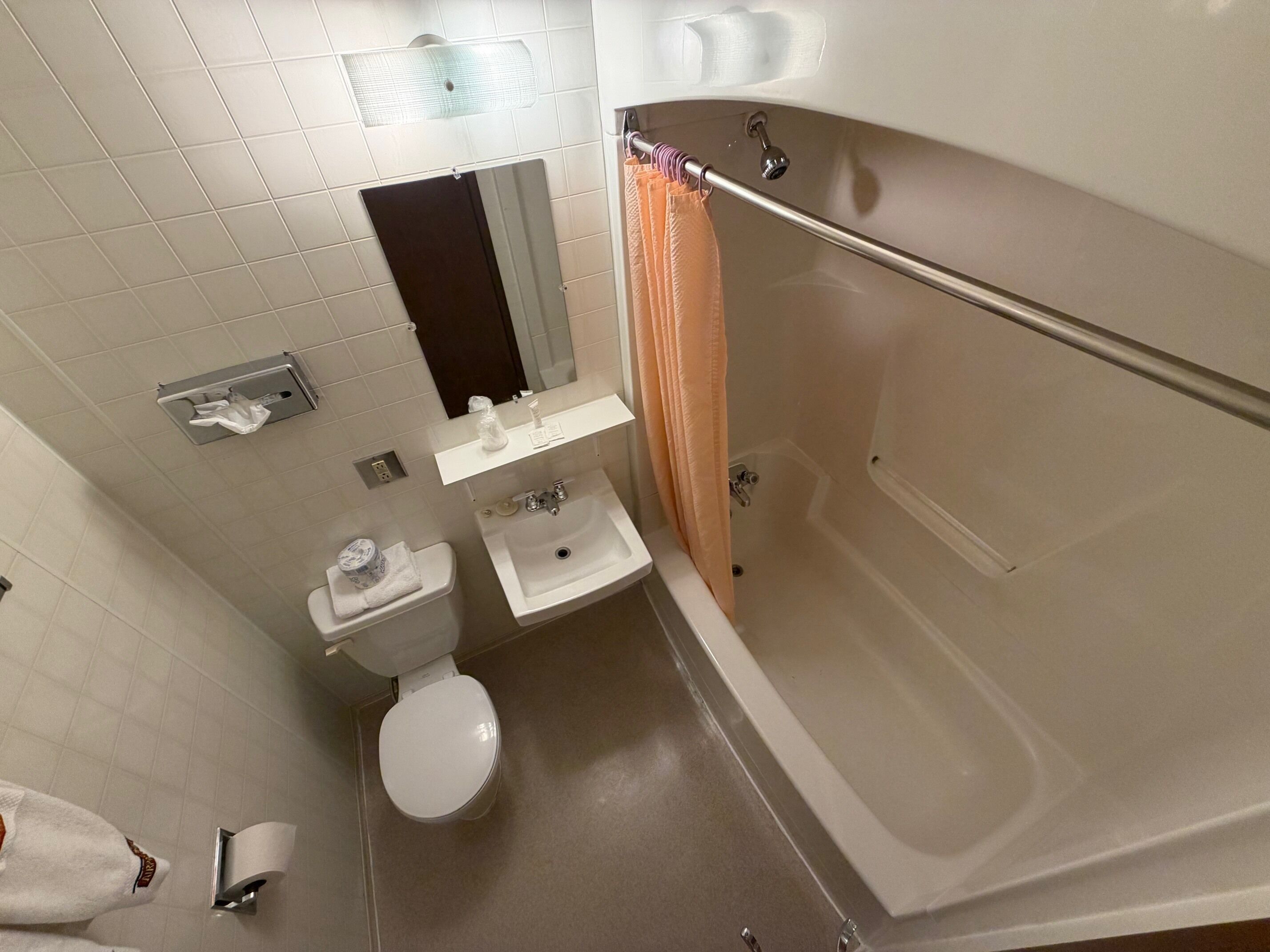 Un baño con inodoro, lavabo, espejo y bañera.