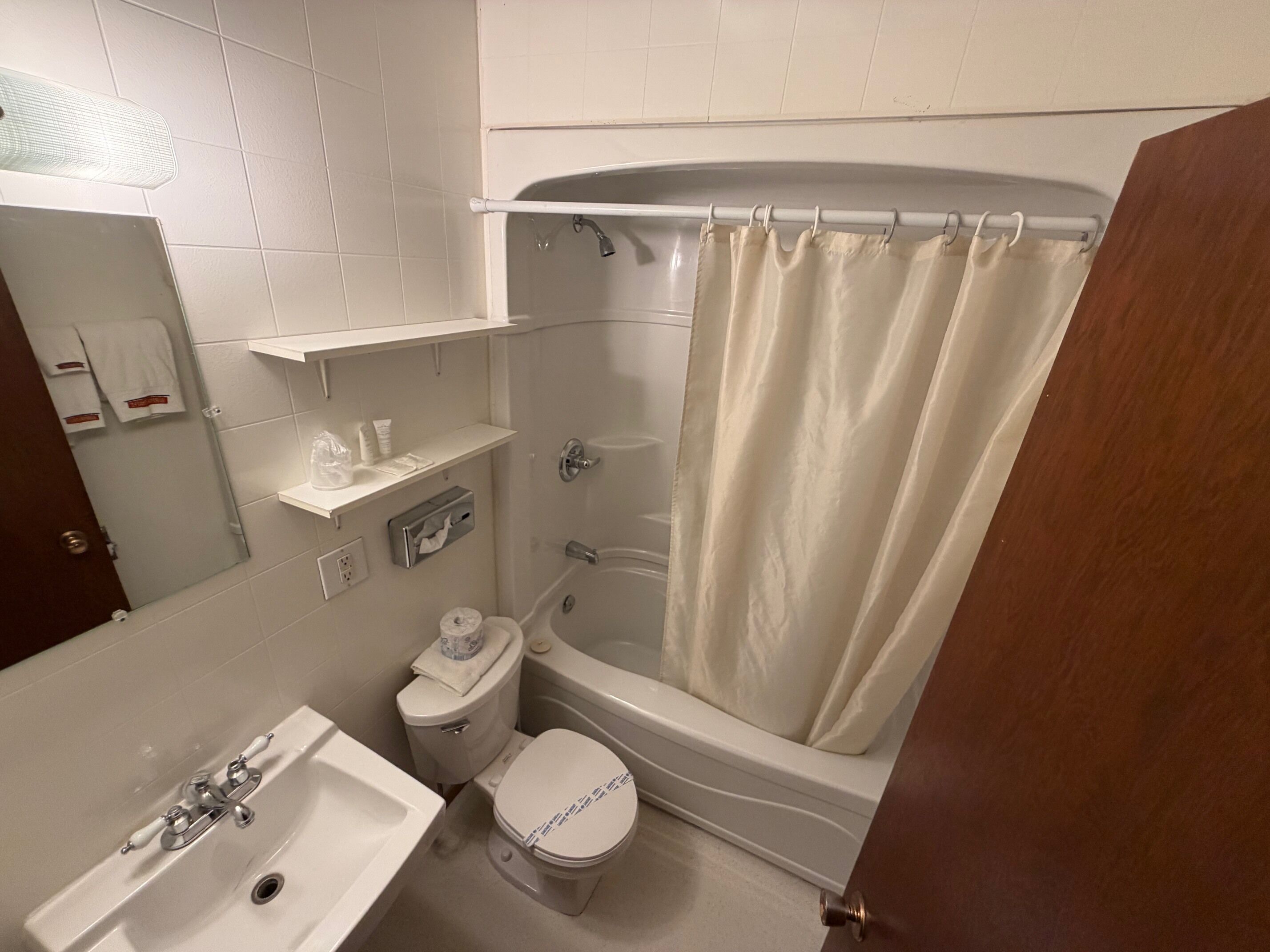 A bathroom with a toilet, sink, and bathtub.