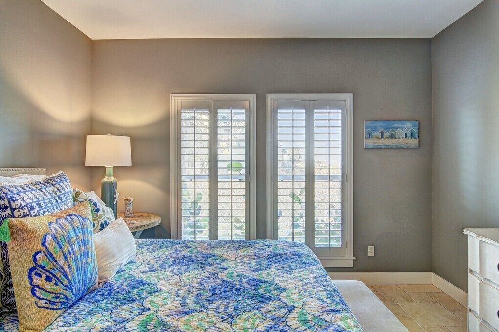 A bedroom with a bed, a nightstand, a lamp, and a painting on the wall.