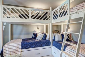 Cozy bunk bed setup with a lower storage drawer and ladder access to the upper bunk.