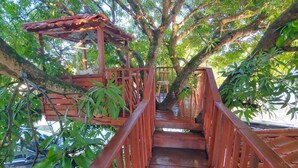 A wooden bridge with a covered shelter, surrounded by lush greenery. - Villa San Juan a special place in Tela (El Triunfo de La Cruz)