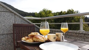A breakfast setup with croissants, orange juice, and coffee mugs on a balcony with a scenic mountain view. - EXCLUSIVE HOUSE WITH POOL IN GONDOMAR (gondomar)