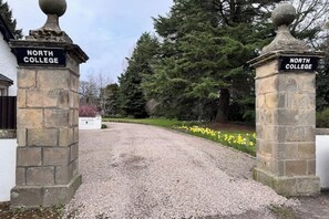 Un camino de grava que conduce a un edificio con pilares de piedra con la inscripción "North College".