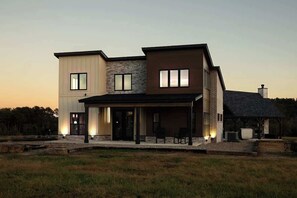 A modern two-story house with a covered patio area.