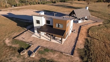 Una casa moderna de dos pisos con un amplio patio y un garaje independiente.