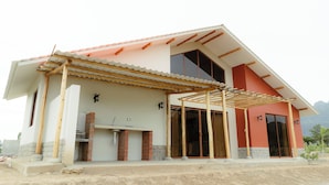 A modern house with a covered patio, a brick fireplace, and large sliding glass doors. - Casa Hacienda Las Palmeras (Patapo)