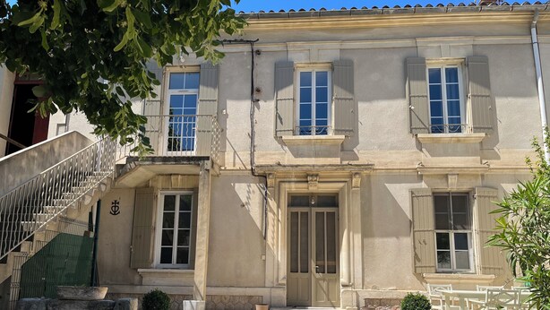 A building with a central entrance, a staircase, and two potted plants. - House in the village, near Avignon (Barbentane)