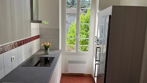 A kitchen with a window, a stove, and a refrigerator. - House in the village, near Avignon (Barbentane)