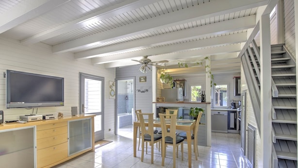 Una cocina amplia con comedor, televisor y escalera.