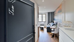 A modern living room with a sofa, a small table, and a chair. - Tom 01 - 5min à pied de la Plage (Fréhel)