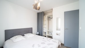 A bedroom with a bed, a wardrobe, and a door.