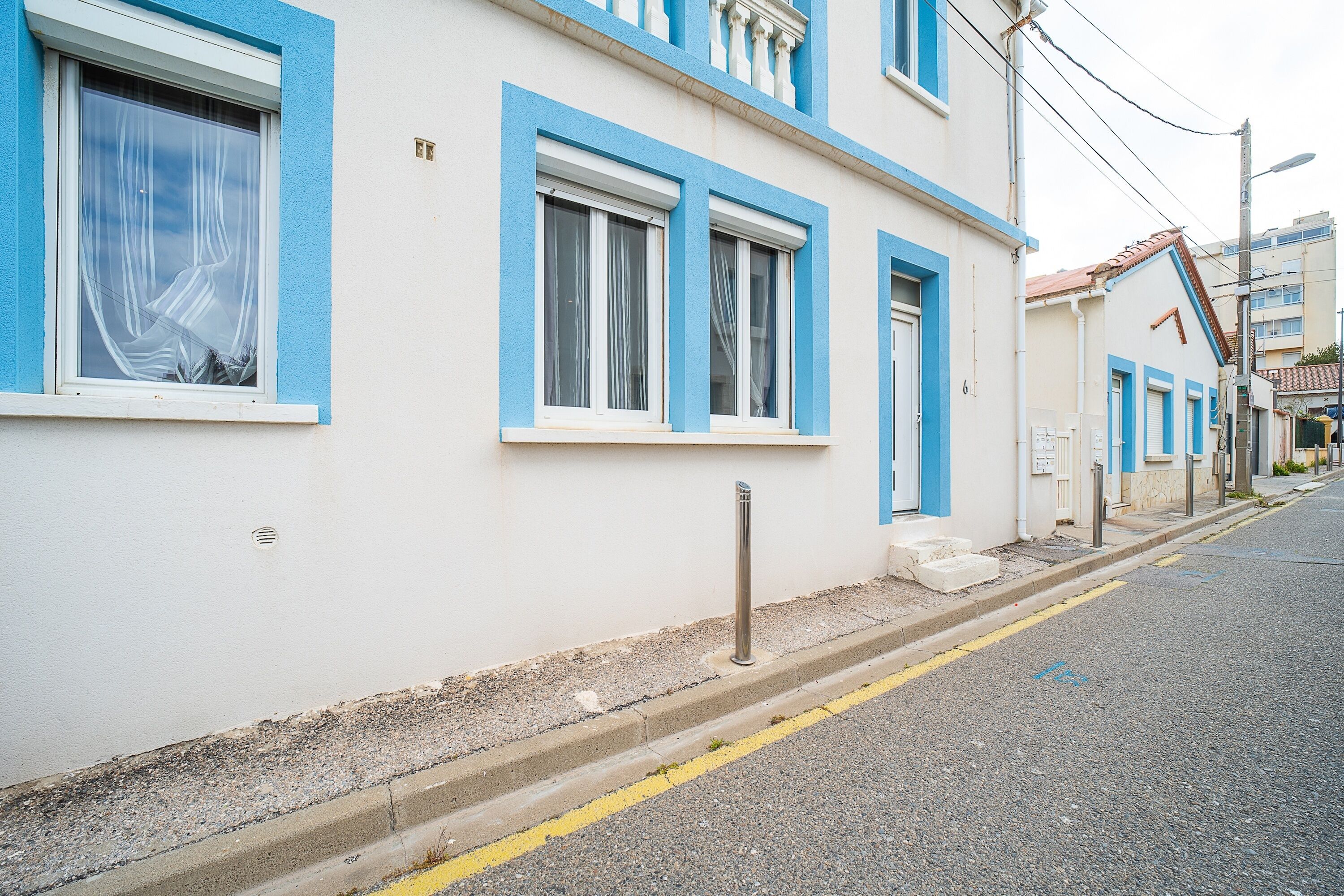 A building with blue-framed windows and a yellow road marking.