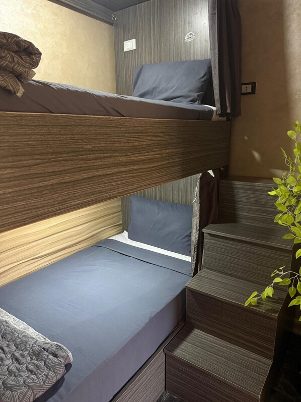 A bunk bed with a lower bunk and a small seating area below. - Sunset Hostel (Cairo)