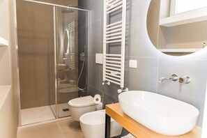 Een douche, een haardroger, een bidet, handdoeken