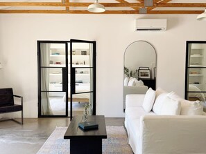 Un saló modern amb un sofà, una taula de centre i un mirall gran.