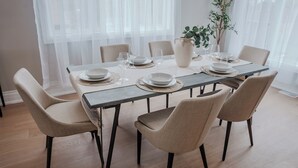Een eetruimte met een rechthoekige tafel voor zes personen, omringd door zes stoelen.