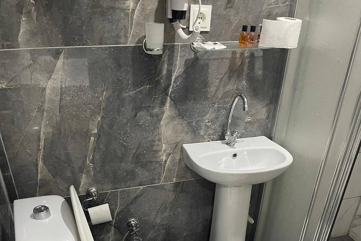 A bathroom with a toilet, sink, and shower.