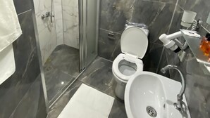 Ein modernes Badezimmer mit einer Duschkabine, einer Toilette und einem Waschbecken.