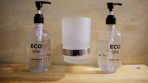 Three bottles of ECO SPA shampoo and bath gel on a wooden surface. - Serenity Boutique Hotel (Paje)