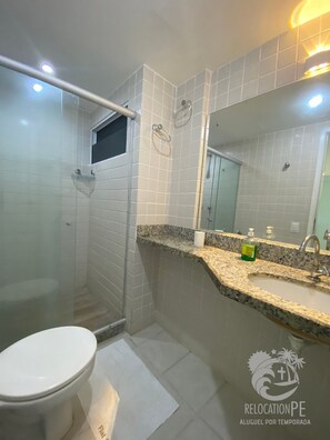 Eenvoudig appartement | Badkamer | Een douche, een haardroger, handdoeken, zeep