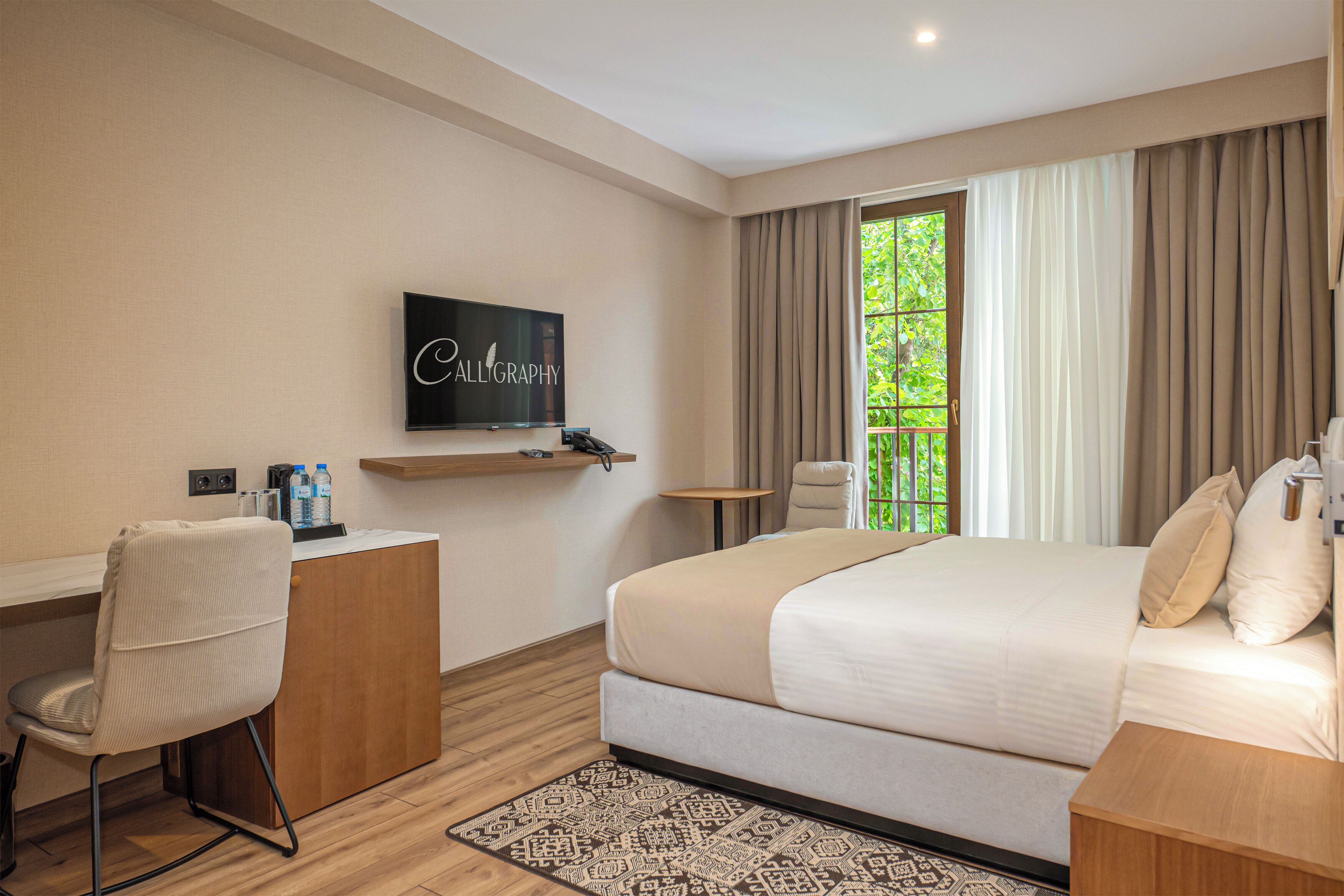 A hotel room with a bed, a desk, a chair, a television, and a window with curtains.