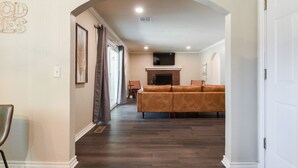 A living room with a fireplace, a sofa, and a television mounted on the wall.