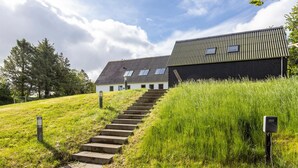 En bygning med moderne design, kendetegnet ved et skråt tag og en trappe til indgangen.
