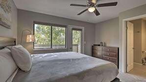 A bedroom with a bed, a ceiling fan, a dresser, and a window.