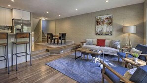A modern living space with a kitchen, dining area, and seating area.