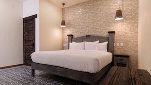 Ein Schlafzimmer mit einem Bett, zwei Nachttischen, einer Ablage und einer hölzernen Bank.