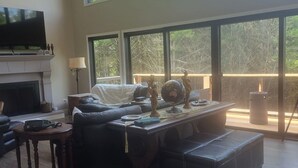 Un salón amplio con chimenea, ventanas grandes y una zona de estar acogedora.