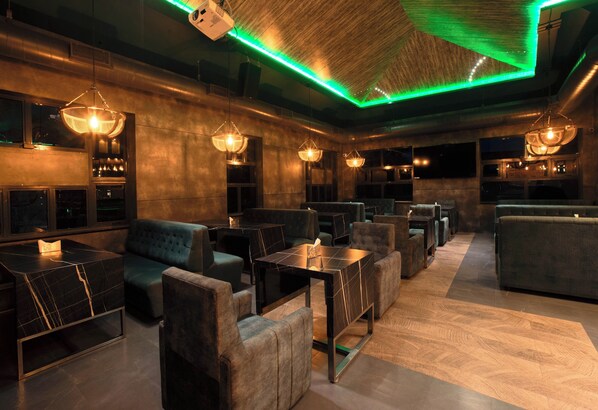 Un espace de détente moderne, doté de canapés, de tables et d’un éclairage d’ambiance.